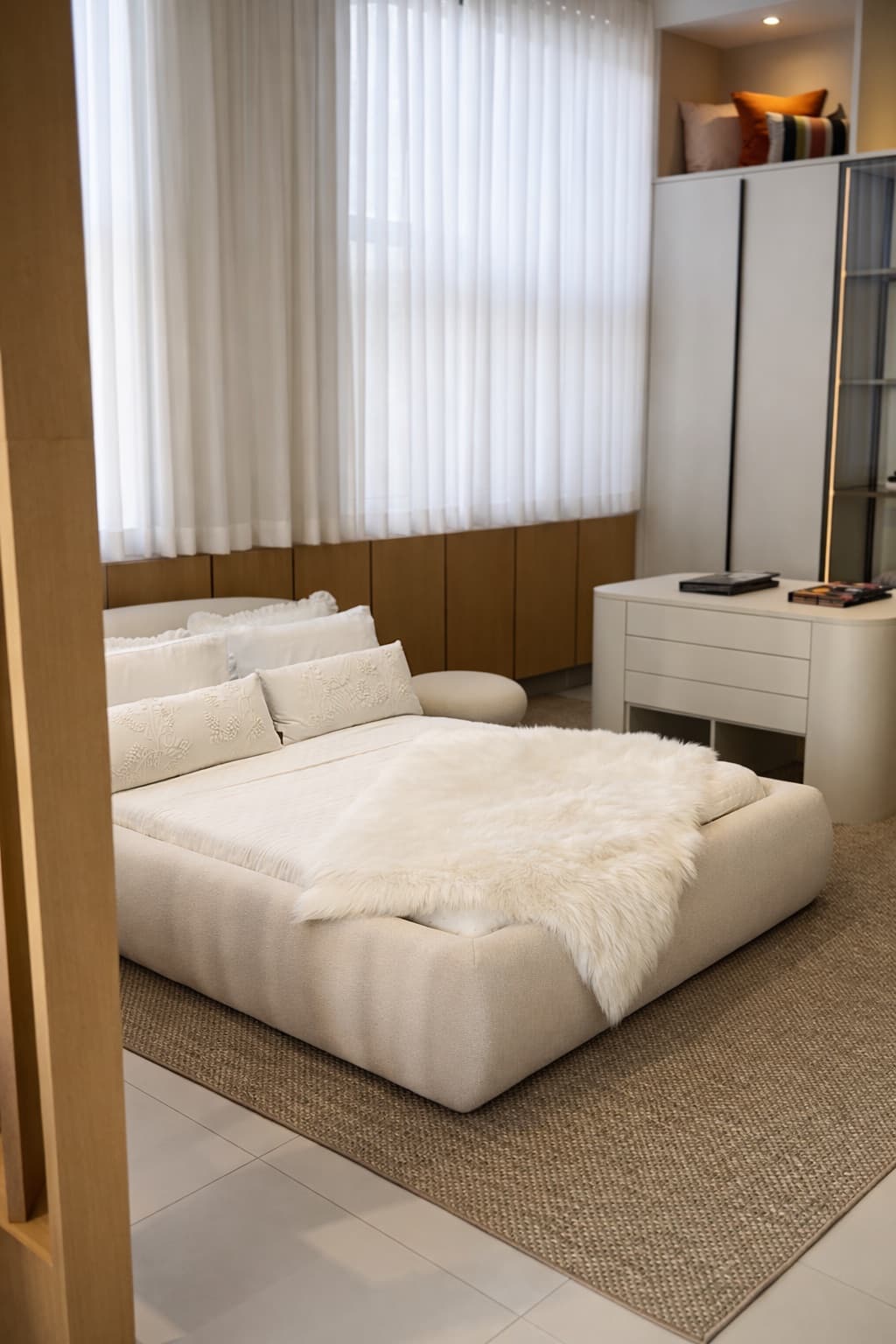 Quarto do showroom Daniela Prado com marcenaria em madeira e formas suaves
